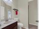 Bathroom with a single sink vanity, toilet, and view of the glass-blocked window at 3259 Alling Ct, Deltona, FL 32725