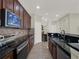 Stylish kitchen featuring dark cabinets, granite countertops, and stainless steel appliances at 3259 Alling Ct, Deltona, FL 32725