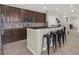 Open concept kitchen features dark wood cabinets and black granite counters and seating for four at 3259 Alling Ct, Deltona, FL 32725