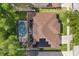 An aerial view of the home showcases its roof, solar panels, screened pool, landscaping, and its position in the neighborhood at 356 Via Tuscany Loop, Lake Mary, FL 32746