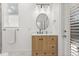 Bright bathroom featuring modern vanity, round mirror, tub with tiled walls, and white marble flooring at 356 Via Tuscany Loop, Lake Mary, FL 32746