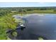 An aerial view captures a tranquil lake with a dock and gazebo, surrounded by lush greenery, offering a peaceful retreat at 356 Via Tuscany Loop, Lake Mary, FL 32746