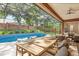 A sparkling blue pool, surrounded by a screened enclosure, lush greenery, and outdoor seating, creates a private backyard oasis at 356 Via Tuscany Loop, Lake Mary, FL 32746