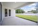 Covered back patio that overlooks a lush, green backyard and white fence at 3944 Sw 130Th Loop, Ocala, FL 34473