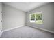 Bedroom with neutral walls, carpet, window view of exterior and base molding at 3944 Sw 130Th Loop, Ocala, FL 34473