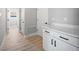 Hallway featuring wood floors, storage cabinets, and white doors at 3944 Sw 130Th Loop, Ocala, FL 34473