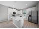 Bright kitchen with stainless steel appliances, quartz countertops, center island and sleek, all-white cabinetry at 3944 Sw 130Th Loop, Ocala, FL 34473