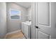 Bright laundry room featuring modern appliances, storage, and a window providing natural light at 3944 Sw 130Th Loop, Ocala, FL 34473