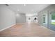 Open living space with sliding glass doors and light-colored wood-style floors leading into kitchen at 3944 Sw 130Th Loop, Ocala, FL 34473