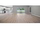 Open living space with sliding glass doors to the backyard and light-colored wood-style floors at 3944 Sw 130Th Loop, Ocala, FL 34473