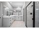 Bright bathroom with double vanity, marble floors, and glass enclosed shower with black hardware at 3944 Sw 130Th Loop, Ocala, FL 34473