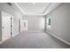 Spacious bedroom with neutral walls, carpet and tray ceiling with access to ensuite bathroom at 3944 Sw 130Th Loop, Ocala, FL 34473