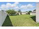 Spacious, well-maintained back yard with lush green grass, mature trees, and a sturdy white fence at 4208 Lugano Ct, Kissimmee, FL 34746