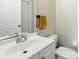 Bathroom featuring a white sink, toilet, and a framed mirror at 4208 Lugano Ct, Kissimmee, FL 34746