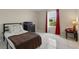 Cozy bedroom with neutral walls, a single bed, tile floor, and a window with red curtains at 4208 Lugano Ct, Kissimmee, FL 34746