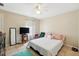 Charming bedroom with tile floors, a ceiling fan, large windows, and a comfortable queen-size bed at 4208 Lugano Ct, Kissimmee, FL 34746