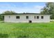 A view of the house's backyard and rear exterior with simple landscaping at 5115 W Livingston St, Orlando, FL 32811