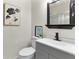 Bathroom features a vanity with a gray cabinet, black faucet, decorative painting, and a sliding glass shower door at 5115 W Livingston St, Orlando, FL 32811