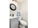 Bathroom showcasing vanity with gray cabinets, a modern black faucet, and round mirror at 5115 W Livingston St, Orlando, FL 32811
