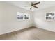 Empty bedroom with neutral walls, wood-look floors, and natural light from two windows at 5115 W Livingston St, Orlando, FL 32811