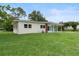 View of home with manicured lawn, white siding, brick accents, and covered parking at 5115 W Livingston St, Orlando, FL 32811
