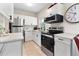 Modern kitchen with white cabinets, stainless steel appliances, and plenty of counter space at 5115 W Livingston St, Orlando, FL 32811