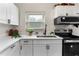 Well-lit kitchen featuring white cabinets, quartz countertops and stainless steel appliances at 5115 W Livingston St, Orlando, FL 32811