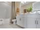 Clean and bright bathroom featuring double vanity, white cabinetry, and shower-tub combination at 5684 Gingham Dr, Kissimmee, FL 34758