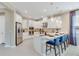 White kitchen with stainless steel appliances and a quartz countertop breakfast bar at 5684 Gingham Dr, Kissimmee, FL 34758