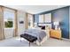 Serene main bedroom featuring a blue accent wall, large windows, and stylish decor at 5684 Gingham Dr, Kissimmee, FL 34758