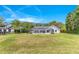 Large backyard with manicured lawn, pool, screened enclosure, and lush landscaping at 5913 Masters Blvd, Orlando, FL 32819