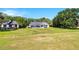 Large grassy backyard with screened pool enclosure, lush landscaping, and blue skies at 5913 Masters Blvd, Orlando, FL 32819