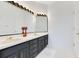 Well-lit bathroom with a double vanity, decorative accents, and neutral tile flooring at 5913 Masters Blvd, Orlando, FL 32819