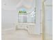 Bright bathroom with dual vanities, large mirrors, and soaking tub under an arched window at 5913 Masters Blvd, Orlando, FL 32819