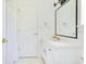 Bathroom with white vanity, mirror, and door with silver fixtures at 5913 Masters Blvd, Orlando, FL 32819