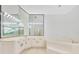 Bathroom featuring dual sinks, large mirrors, a soaking tub, and contemporary lighting at 5913 Masters Blvd, Orlando, FL 32819