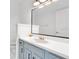 Bright bathroom featuring a vanity with blue cabinets and a large mirror at 5913 Masters Blvd, Orlando, FL 32819