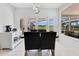 Bright dining area with white cabinetry, modern lighting, and views of the pool and green lawn at 5913 Masters Blvd, Orlando, FL 32819