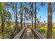 Scenic wooden walkway leading to a private dock with lush greenery and serene water views at 5913 Masters Blvd, Orlando, FL 32819