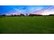 Expansive golf course with lush green fairways and practice areas under a colorful sky at 5913 Masters Blvd, Orlando, FL 32819