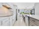 Kitchen with island featuring bar seating, white cabinets, stainless steel appliances, and cooktop at 5913 Masters Blvd, Orlando, FL 32819
