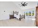 Spacious main bedroom with a fan, light floors, and french doors leading to a pool at 5913 Masters Blvd, Orlando, FL 32819