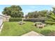 Community green space with picnic tables, mature trees, and well-maintained landscaping for outdoor enjoyment at 644 Villa Ct, Clermont, FL 34711