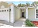 Inviting home entrance with a covered walkway, neutral paint scheme, and well-maintained landscaping at 644 Villa Ct, Clermont, FL 34711