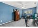 Bedroom with blue walls features a ceiling fan, a window, and carpeted floors at 7466 Canford Ct # 25, Winter Park, FL 32792