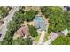 Aerial view of a house with large lot showcasing the pool, mature trees, and neighborhood at 7838 Rollingridge Ct, Orlando, FL 32835