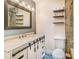 Well-lit bathroom featuring an undermount sink with marble countertop, modern fixtures, and floating shelves at 7838 Rollingridge Ct, Orlando, FL 32835