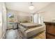 Stunning main bedroom with a tufted headboard, hardwood floors, and natural lighting from two large windows at 7838 Rollingridge Ct, Orlando, FL 32835