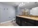 Bathroom featuring double vanity with black cabinets and granite countertops at 8057 John Hancock Dr, Winter Garden, FL 34787