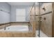 Bathroom with tub and glass enclosed shower with neutral tile surround at 8057 John Hancock Dr, Winter Garden, FL 34787